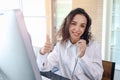 Smiling beautiful woman with headphones give thumb up at call center service desk consultant, call center agent with headset talk Royalty Free Stock Photo