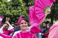 Smiling beautiful woman with a pinky hand fan and pink costume in Orange Blossom Carnival parade`s opening. Adana - Turkey