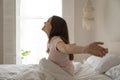 Smiling beautiful woman sitting in bed, stretching after awakening Royalty Free Stock Photo