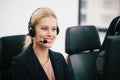 A smiling  beautiful woman sitting in a customer service department office with headset working in call center Royalty Free Stock Photo