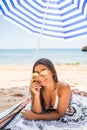 Smiling beautiful latin woman sunbathing on a beach under umbrella on the sea beach Royalty Free Stock Photo