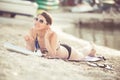 Smiling beautiful woman sunbathing in a bikini on a beach at tropical travel resort Royalty Free Stock Photo