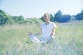 Smiling beautiful yoga girl meditating for openness in green environment