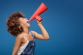 Afro young girl screaming by red megaphone. Royalty Free Stock Photo