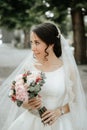 Smiling beautiful young bride in wedding dress with bouquet of flowers Royalty Free Stock Photo