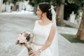 Smiling beautiful young bride in wedding dress with bouquet of flowers Royalty Free Stock Photo