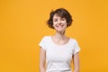 Smiling beautiful young brunette woman girl in white t-shirt posing isolated on yellow orange background studio portrait Royalty Free Stock Photo