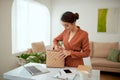 Smiling beautiful young business woman holding one open pink leather handbag putting water bottle inside Royalty Free Stock Photo