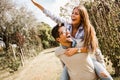 Beautiful young couple in love having fun in park. Handsome man giving piggy back to his girlfriend Royalty Free Stock Photo