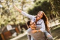 Beautiful young couple in love having fun in park. Handsome man giving piggy back to his girlfriend Royalty Free Stock Photo