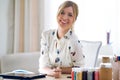 Smiling beautiful young designer woman working with her digital tablet while looking at the camera at the office Royalty Free Stock Photo