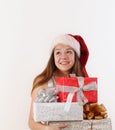 Smiling beautiful young girl in Santa hat with gifts dreaming ab Royalty Free Stock Photo