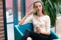 Smiling beautiful young girl talking on phone and drinking cocktail at the cafe. Portrait of beautiful smiling woman sitting on a Royalty Free Stock Photo