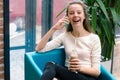 Smiling beautiful young girl talking on phone and drinking cocktail at the cafe. Portrait of beautiful smiling woman sitting on a Royalty Free Stock Photo