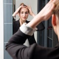 Smiling beautiful young woman checking at her chic hairstyle Royalty Free Stock Photo