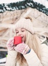 Smiling beautiful young woman drinks a hot cocoa outdoor. Royalty Free Stock Photo