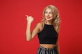 Smiling beautiful young woman girl in black clothes posing isolated on bright red wall background, studio portrait Royalty Free Stock Photo