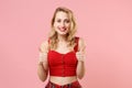 Smiling beautiful young woman girl in red sexy clothes posing isolated on pastel pink wall background studio portrait Royalty Free Stock Photo