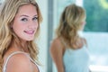 Smiling beautiful young woman looking at herself in the bathroom mirror Royalty Free Stock Photo