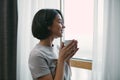 Smiling beautiful young woman looking out window with cup of hot drink relaxing in morning at home. Domestic life Royalty Free Stock Photo