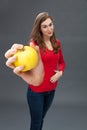 Smiling beautiful young woman touching her stomach for apple appetite