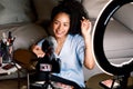 Smiling beauty blogger recording video on DSLR camera