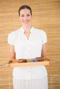 Smiling beauty therapist holding tray of beauty treatments Royalty Free Stock Photo