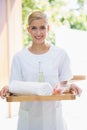 Smiling beauty therapist holding tray of beauty treatments Royalty Free Stock Photo