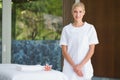 Smiling beauty therapist standing beside massage towel