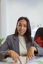 Smiling biracial businesswoman sitting at desk making video call in modern office