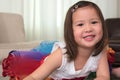Smiling biracial female asian child lying on stomach smiling