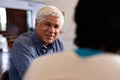 Smiling biracial senior man talking with female friend while sitting for lunch in nursing home Royalty Free Stock Photo
