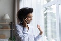 Smiling biracial woman look in window talking on cellphone Royalty Free Stock Photo