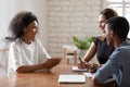 Smiling biracial woman talk with employers at job interview