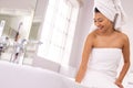 Smiling biracial woman wearing towel in bathroom, preparing bath, with copy space Royalty Free Stock Photo