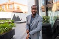 Smiling black businessman is elegantly dressed and is holding his laptop. Confident and happy business manager. Established Royalty Free Stock Photo