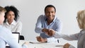 Smiling black businessman handshake female colleague at office briefing Royalty Free Stock Photo