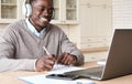 Smiling black businessman having video call on laptop computer in homeoffice.