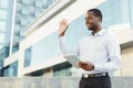 Smiling black businessman with tablet smiling and making welcoming gesture Royalty Free Stock Photo