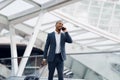 Smiling Black Businessman Talking On Cellphone While Walking With Suitcase In Airport Royalty Free Stock Photo