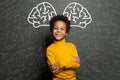 Smiling black child with big brain and science formulas on black, education and brainstorming concept Royalty Free Stock Photo