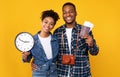 Smiling Black Couple Holding Tickets And Clock Over Yellow Background Royalty Free Stock Photo