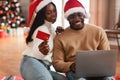 Smiling black couple using laptop showing credit card on Xmas Royalty Free Stock Photo