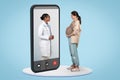 Smiling black doctor consults pregnant patient consultation at pregnancy at big phone screen