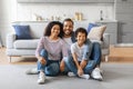 Smiling black family with son sitting on floor in cozy living room Royalty Free Stock Photo