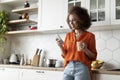 Smiling Black Female Messaging On Smartphone And Drinking Coffee In Kitchen Interior Royalty Free Stock Photo
