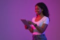 Smiling Black Female Using Digital Tablet While Standing In Neon Light Royalty Free Stock Photo