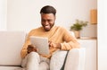 Smiling Guy Using Tablet Enjoying Weekend Sitting On Couch Indoor Royalty Free Stock Photo