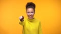 Smiling black lady pointing finger in camera, choosing winner, yellow background Royalty Free Stock Photo