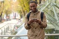 Smiling black male student typing on mobile phone Royalty Free Stock Photo